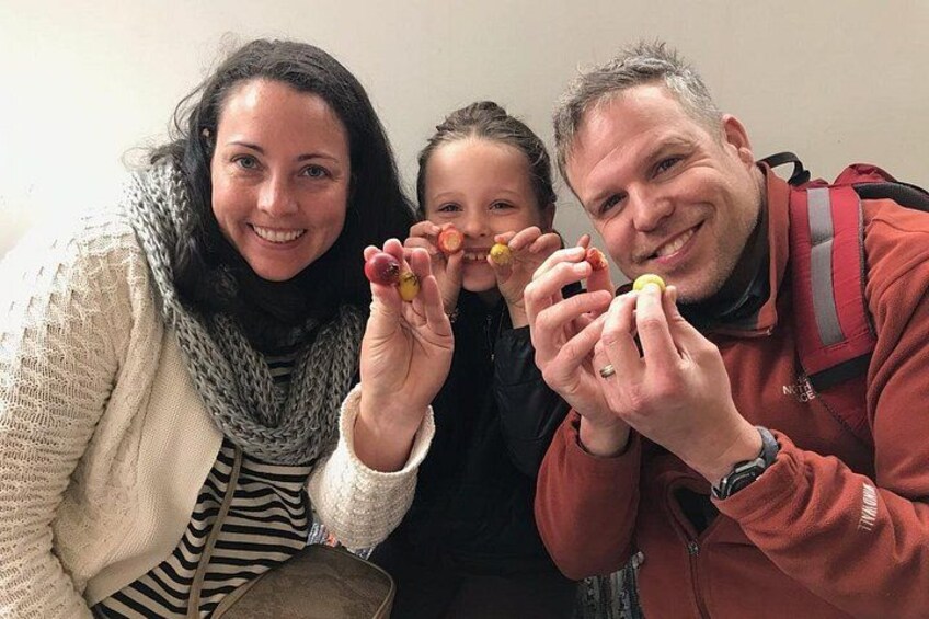 Three people holding food items. 2