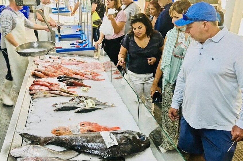 A fish market with various types of fish displayed on a table. 4
