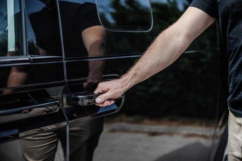 Eine Person öffnet die Autotür. 4