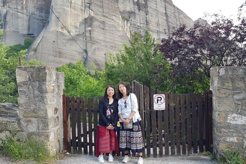 Two people standing in front of a wooden fence with a parking sign. 3