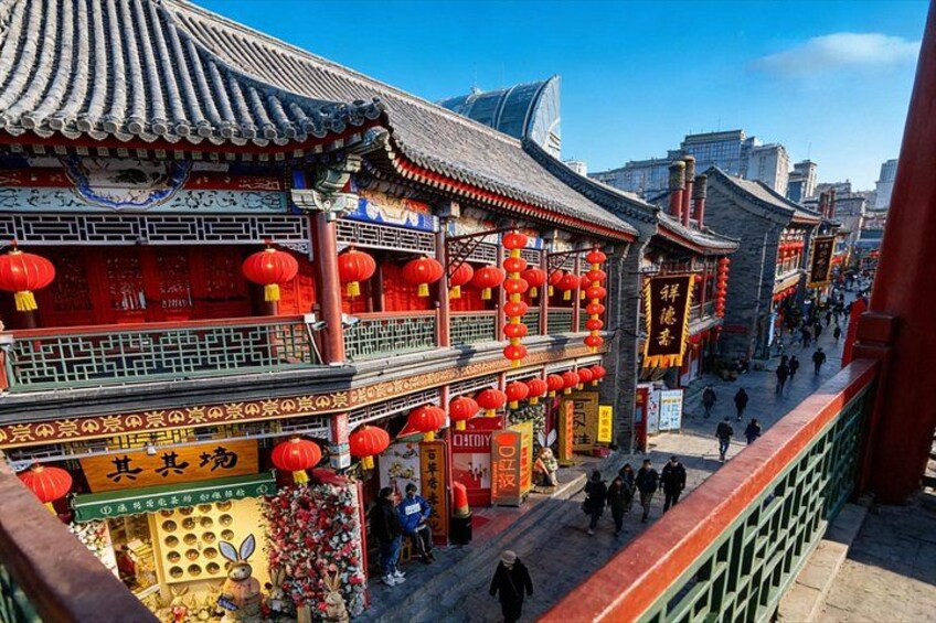 A traditional Chinese street with ornate buildings, red lanterns, and pedestrians. 3