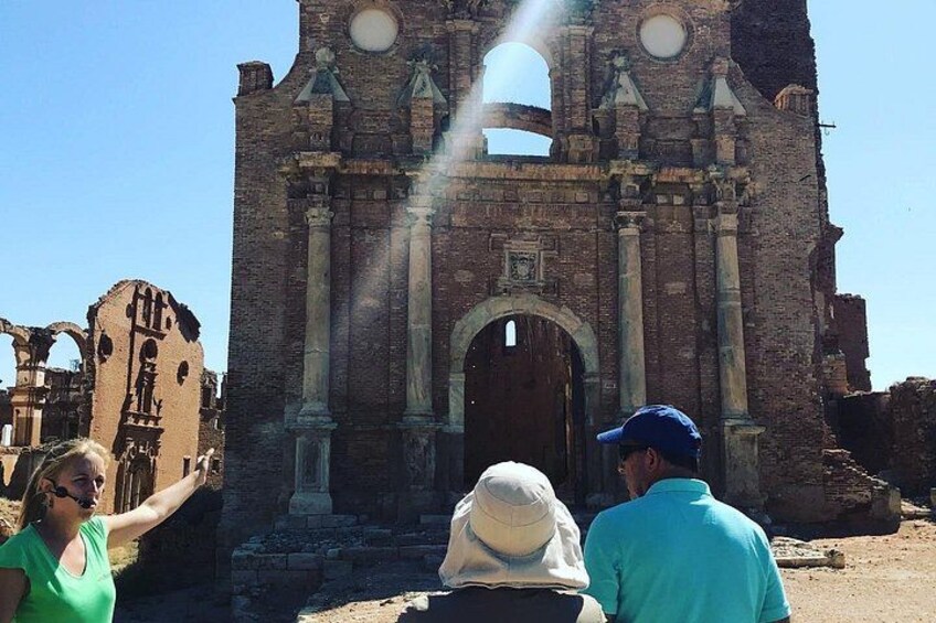 A historical building with arched doorways and columns, partially in ruins. 3
