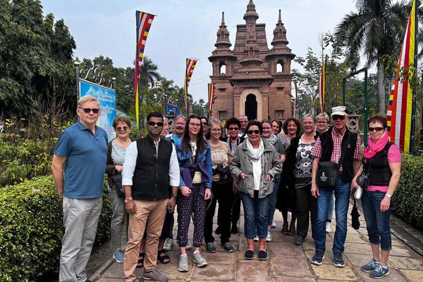Un groupe de personnes se tient devant un bâtiment historique doté de plusieurs tours. 2