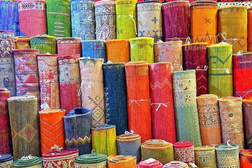 Une collection de tapis colorés, tissés et empilés verticalement. 3