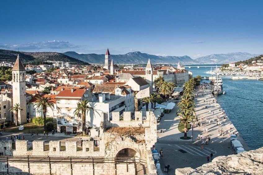 A coastal town with historic buildings, a prominent tower, and a marina. 2