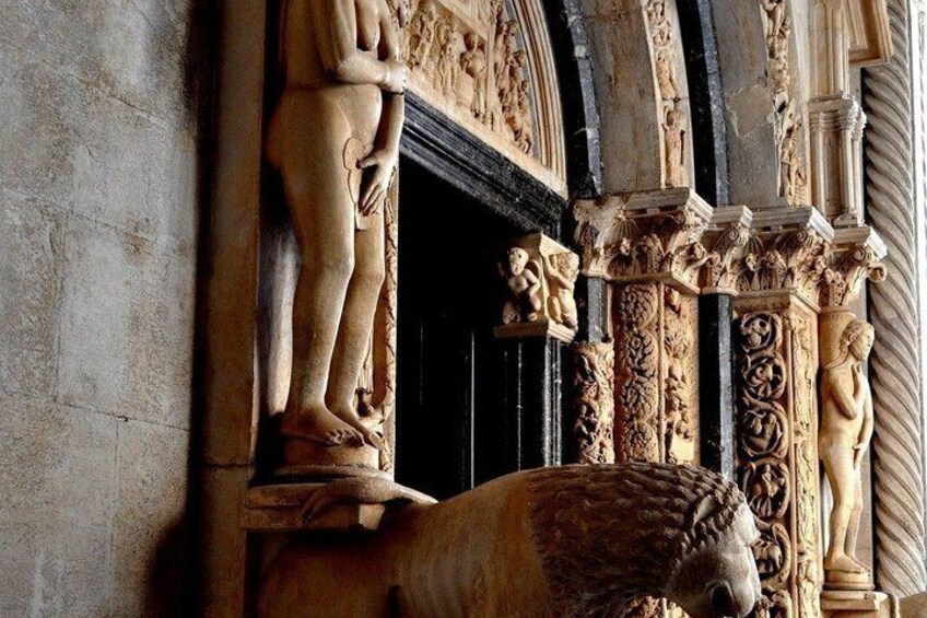 A stone relief sculpture of a human figure and a lion, with intricate carvings and architectural elements. 5