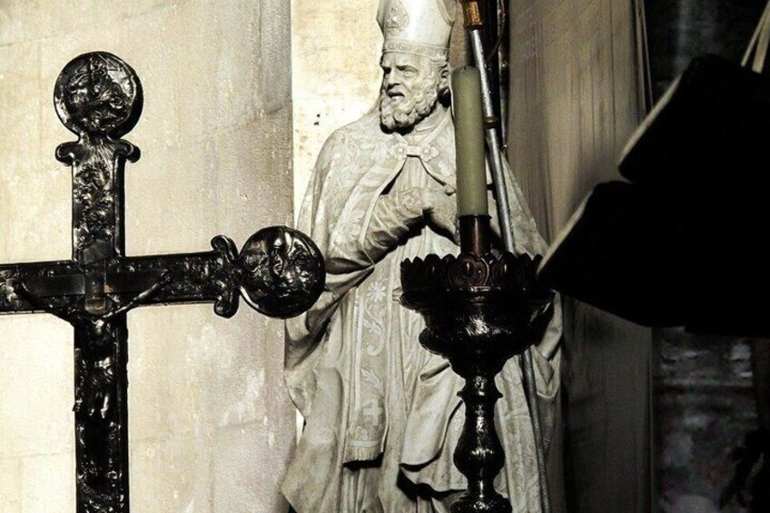 A statue with a candle holder in front of it. 3