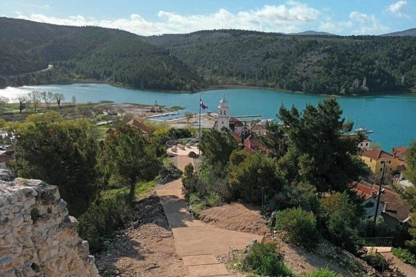 A coastal town with a church, a lake, and surrounding hills. 4