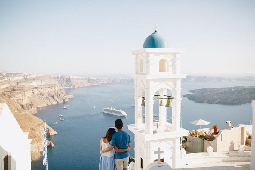 A coastal view with a white building, a blue dome, and a ship in the water. 1