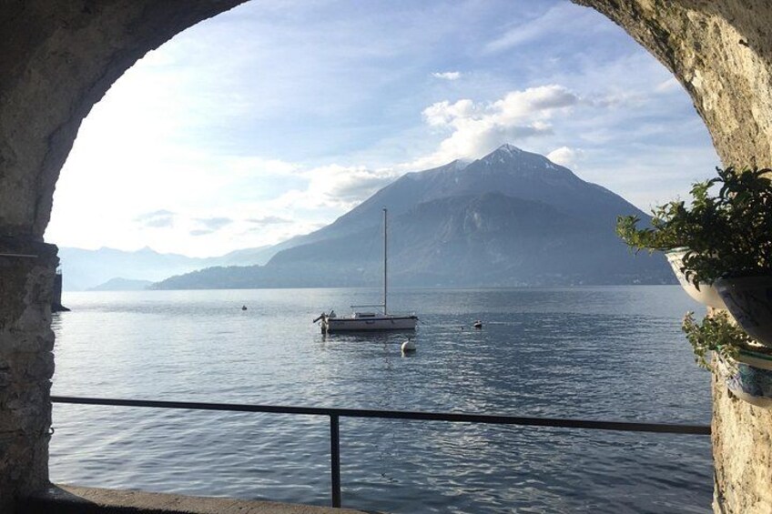 A lake with a sailboat, a mountain in the background, and an archway framing the scene. 5