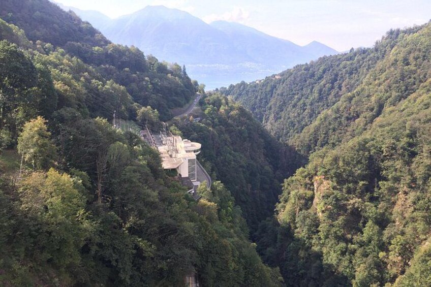 A mountainous landscape with a winding road and a building with a sloped roof. 4