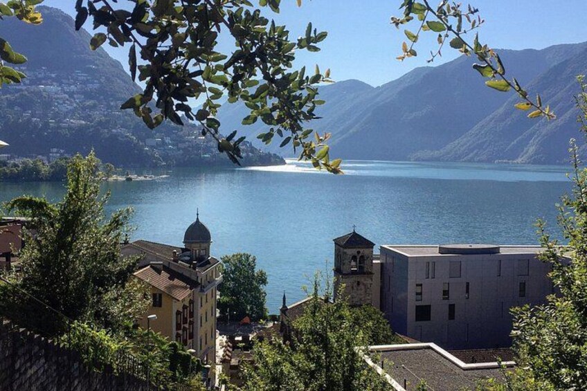 Un lago con edificios y montañas al fondo. 3