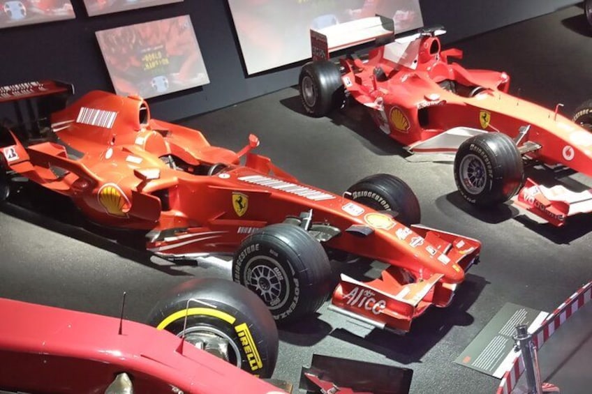 Esposizione di auto di Formula 1 rosse con loghi di sponsorizzazione e marchio visibili. 2
