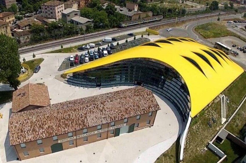 Un edificio moderno con techo amarillo curvado y estructura de ladrillo tradicional. 2