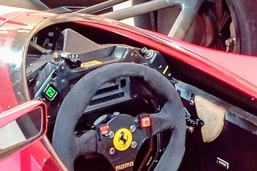 Volante Ferrari con un logo, un display digitale e la leva del cambio. 3
