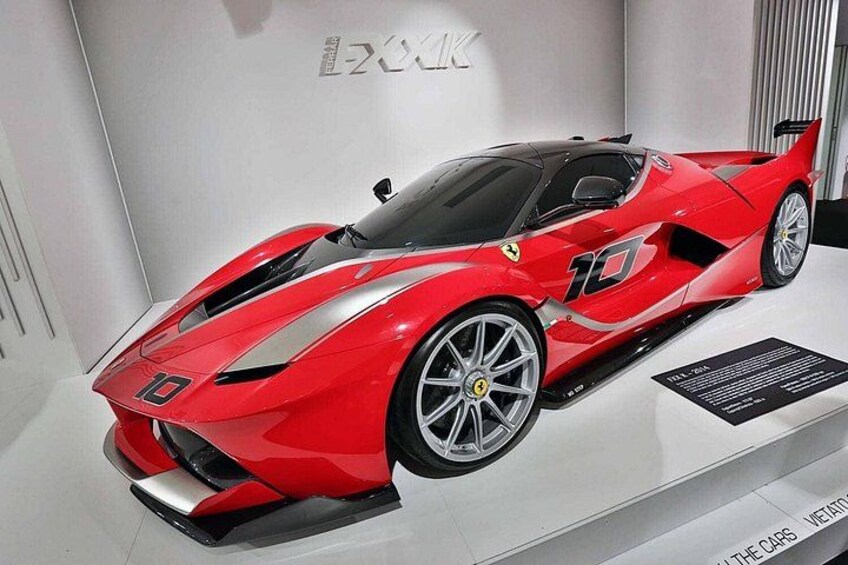 Un coche deportivo rojo con el número 10 en la carrocería, exhibido en una sala de exposición. 4