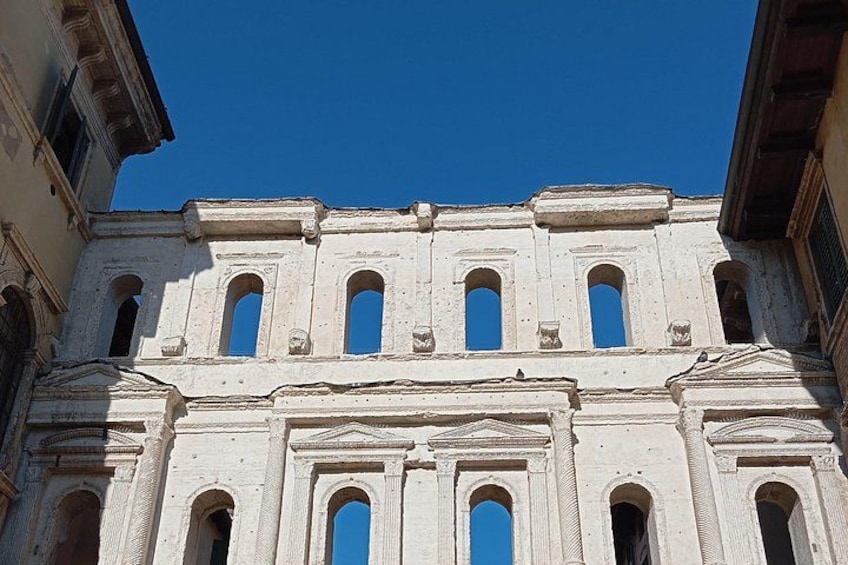 Un bâtiment blanc doté de nombreuses fenêtres en arc de cercle, avec un ciel bleu en arrière-plan. 2