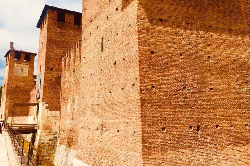 Un mur de briques avec une tour horloge et un escalier. 4