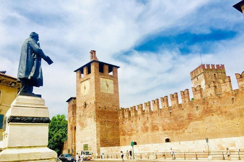 Une fortification historique, avec une statue au premier plan et une tour de l’horloge. 2