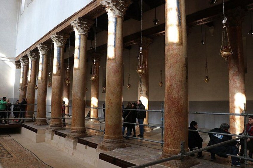 A historical building with large columns and hanging light fixtures. 1