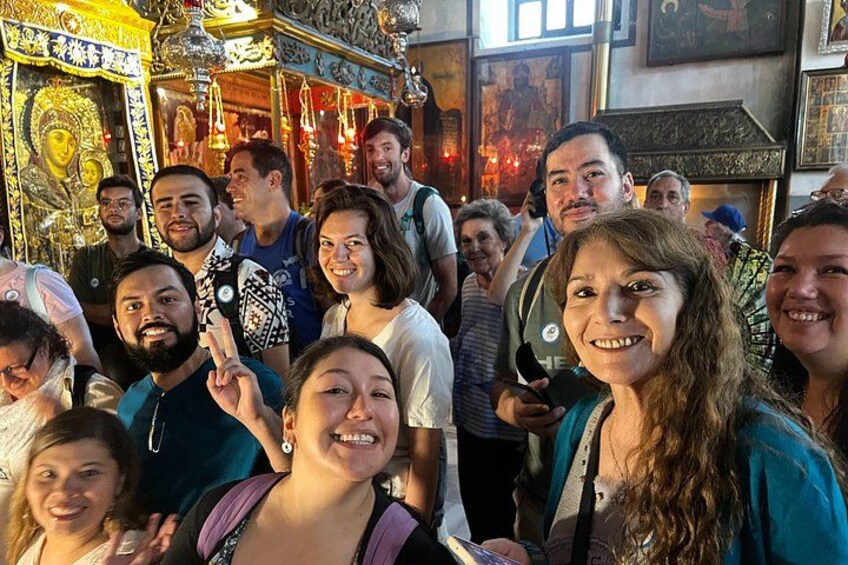 A group of people inside a building with ornate decorations and religious icons. 1