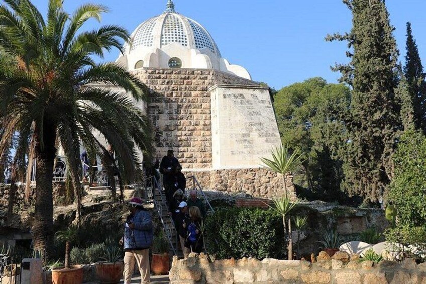 A stone structure with a dome, surrounded by palm trees and other vegetation. 2