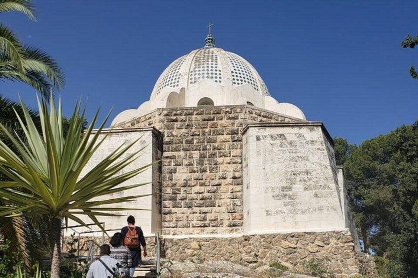 Un edificio de cúpula blanca sobre una base de piedra, rodeado de follaje. 5