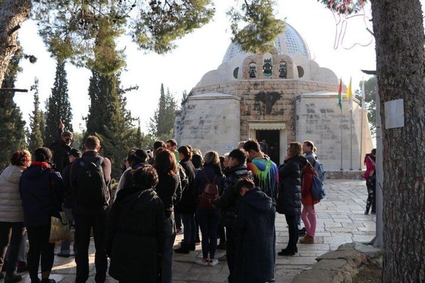 A group of people gathered in front of a white building with a dome, surrounded by trees. 2