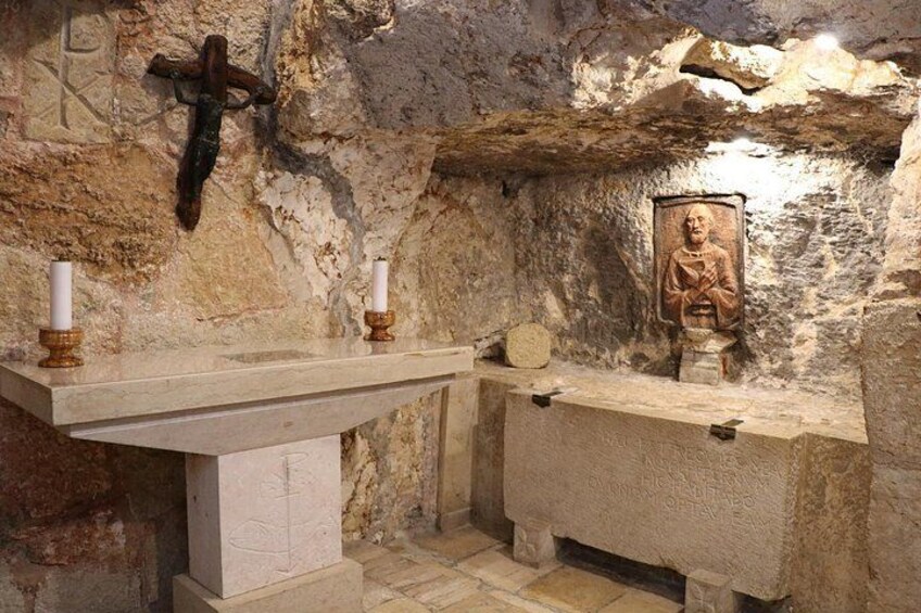 Un altar de piedra con una cruz y un cuadro religioso. 2
