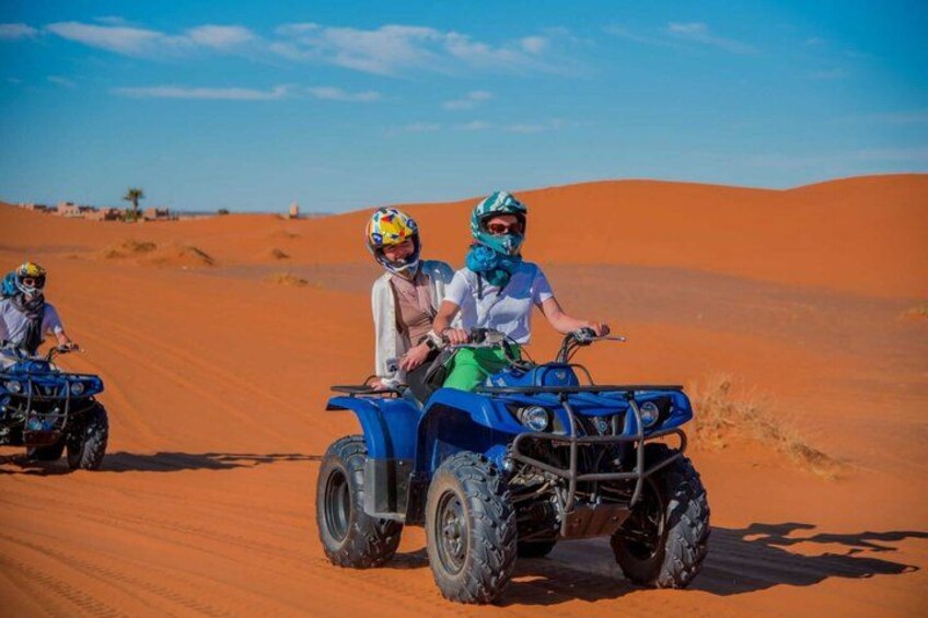 Two people on ATVs in a desert with sand dunes. 5