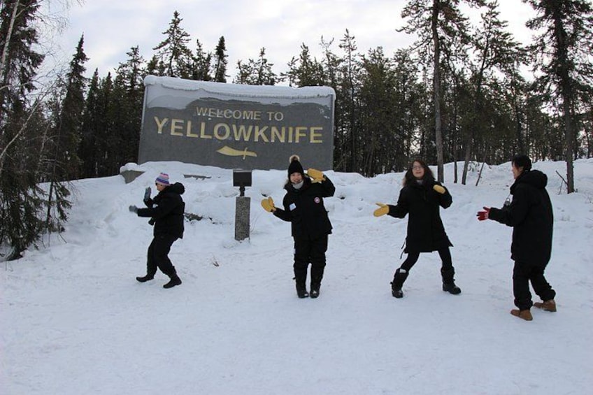 Een besneeerd landschap met een bord waarop staat 'Welcome to Yellowknife'. 3