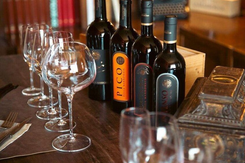 Een tafel met wijnglazen en flessen, waaronder een fles van PICO. 2