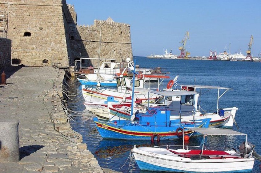 A harbor with several small boats docked near a stone wall. 3