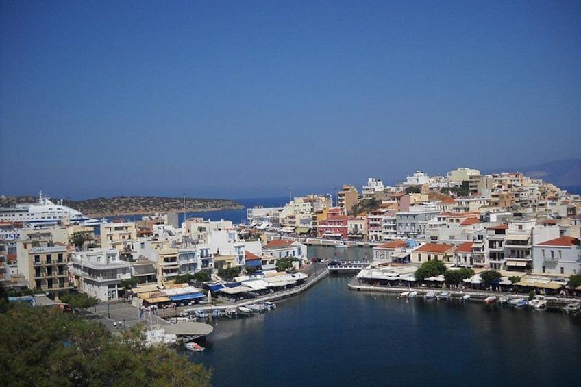 A coastal town with a marina, buildings, and a clear blue sky. 2