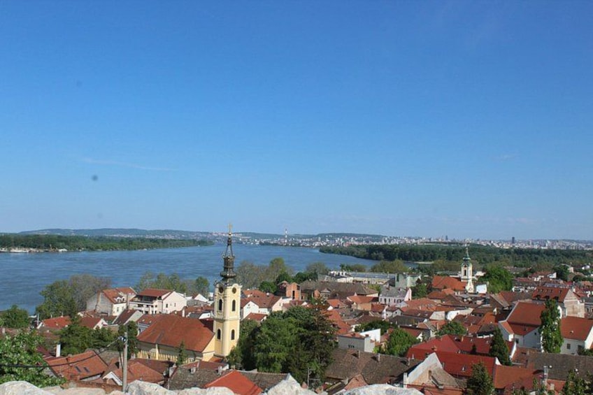 Un río, un pueblo con edificios de tejados rojos y una iglesia destacada con un alto campanario. 3