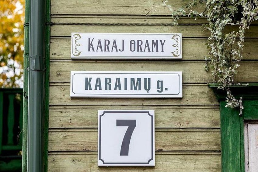 Straatnaambordjes met 'KARAJ ORAMY' en 'KARAIMU g.', en een bord met het getal '7' daaronder. 2