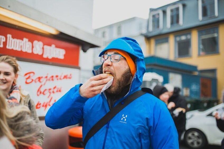 Une personne portant une veste bleue et un bonnet orange est en train de manger. 3
