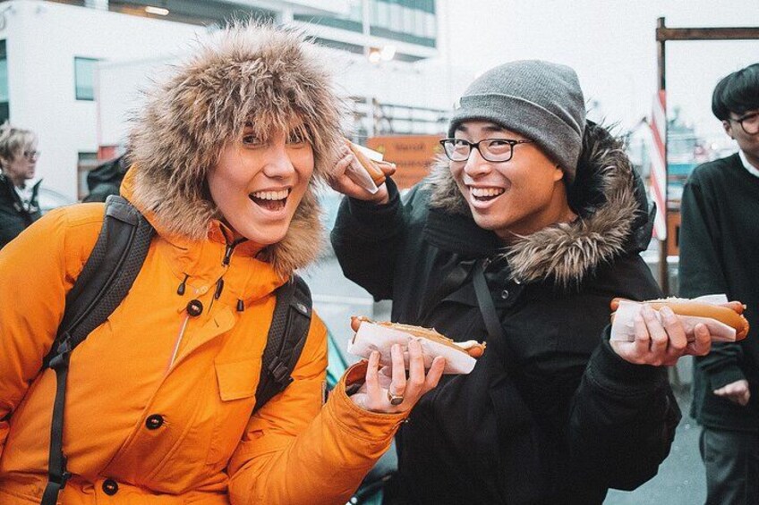 Deux personnes tenant des hot-dogs. 1