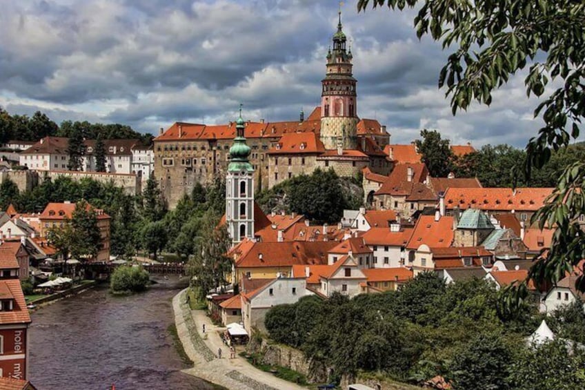 A historic town with a prominent church tower, a river, and a castle. 5