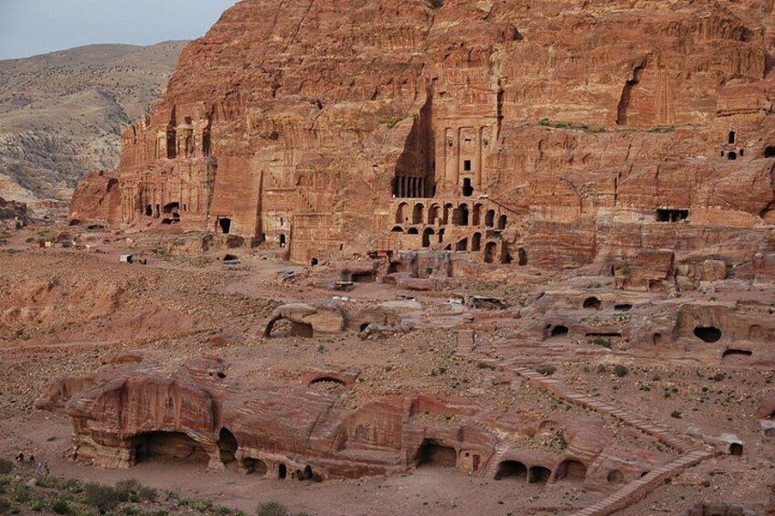 Ancient rock-cut architecture with multiple levels of carved niches and a large, prominent building with a stepped facade. 4