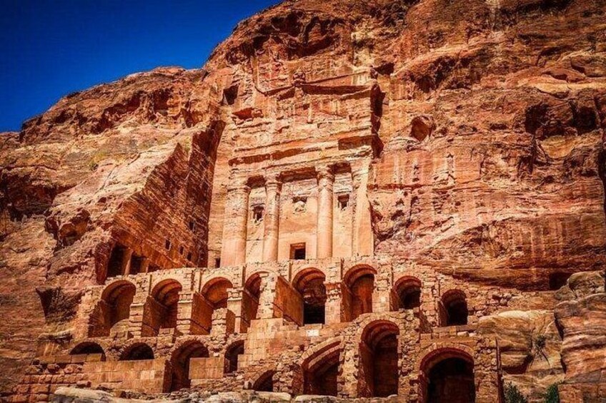A large rock-cut structure with multiple arches and columns, carved into a cliff face. 2