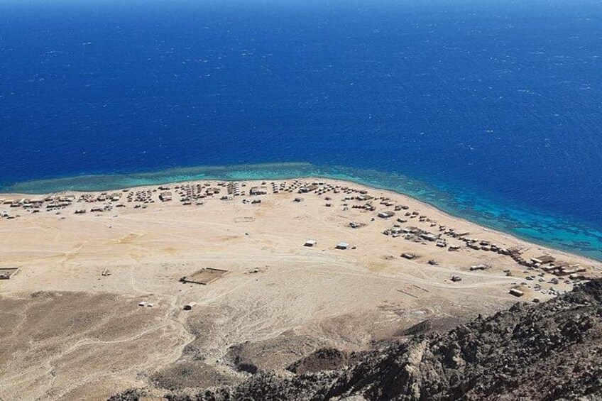 A coastal area with a sandy beach and a clear blue sea. 2