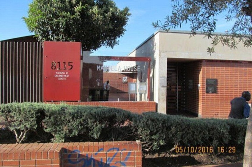 A building with a red sign reading '8115' and a sign for 'Mandel House.' 1