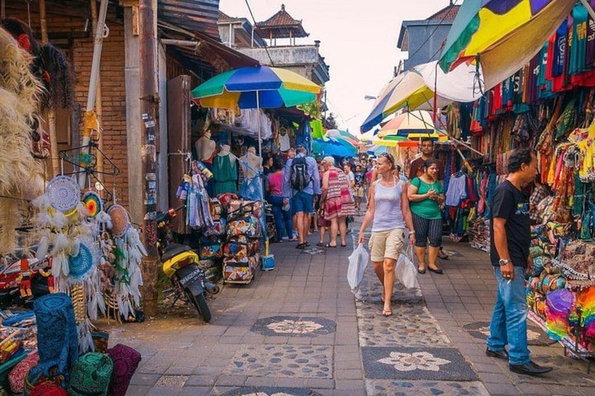 A bustling market with vendors and shoppers, colorful umbrellas, and traditional textiles. 5