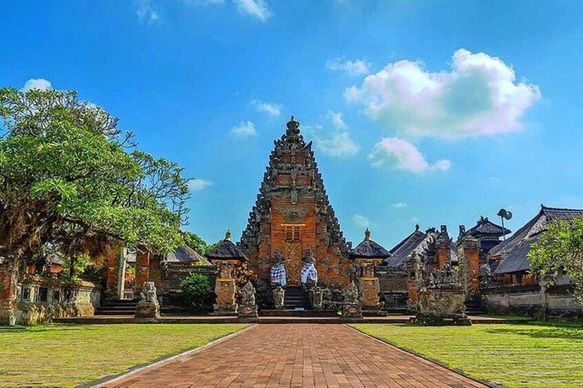 A temple with a central tower, a paved walkway, and traditional buildings. 3