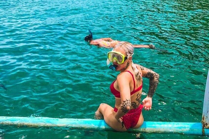 A person in a red swimsuit sitting on a pool edge. 4