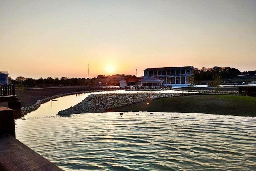 Un atardecer sobre un río tranquilo con un puente y edificios al fondo. 5