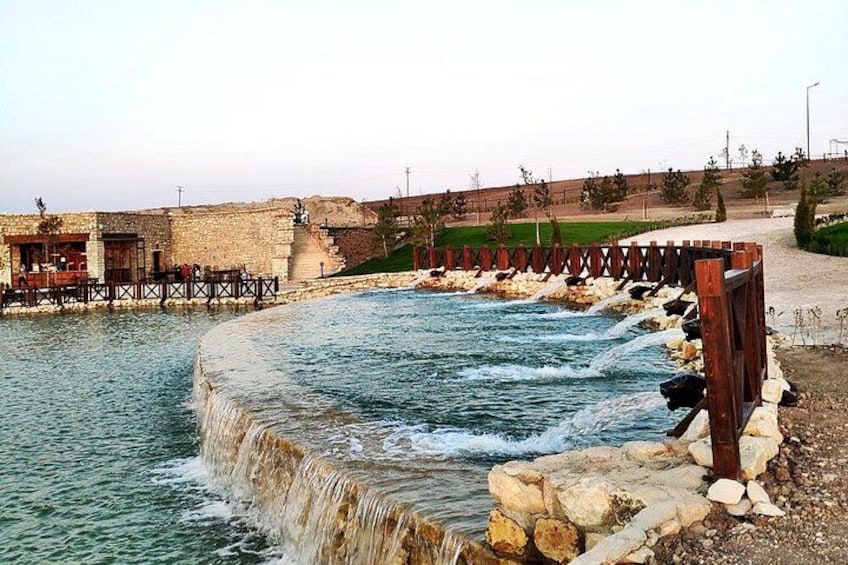 Un río con un muro de piedra y una valla de madera. 4