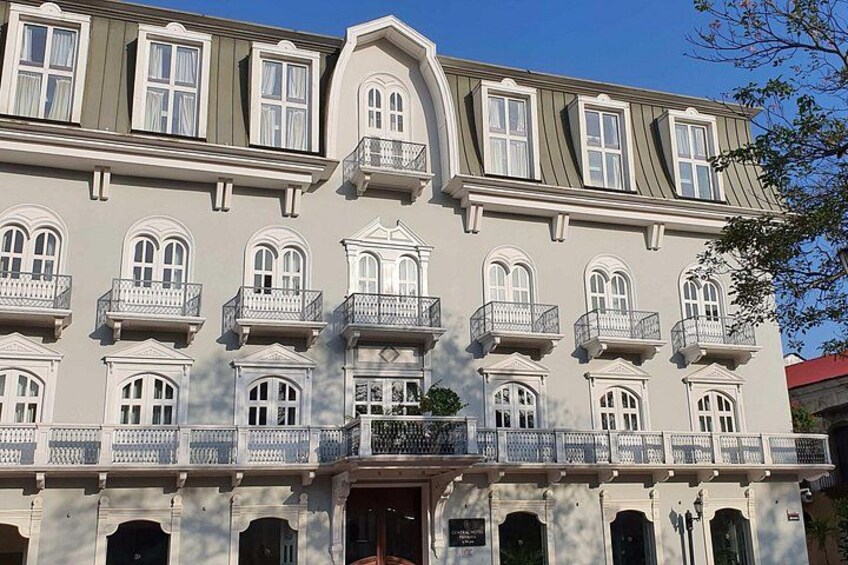 Un immeuble à plusieurs étages, doté de balcons décoratifs et de fenêtres en arc de cercle. 3