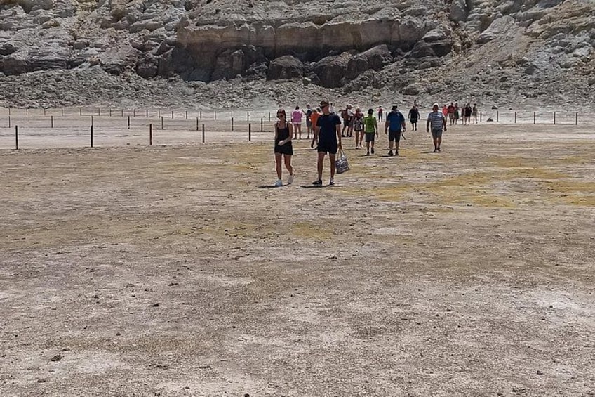 A group of people walking on a rocky terrain with sparse vegetation. 2